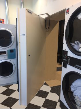 open hidden door as a washer and dryer in a Laundromat.