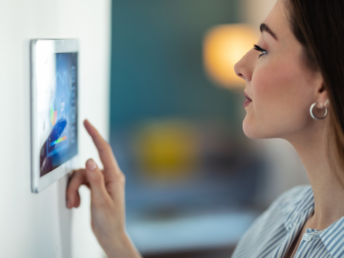 close up of a person interacting with a tablet on a wall.