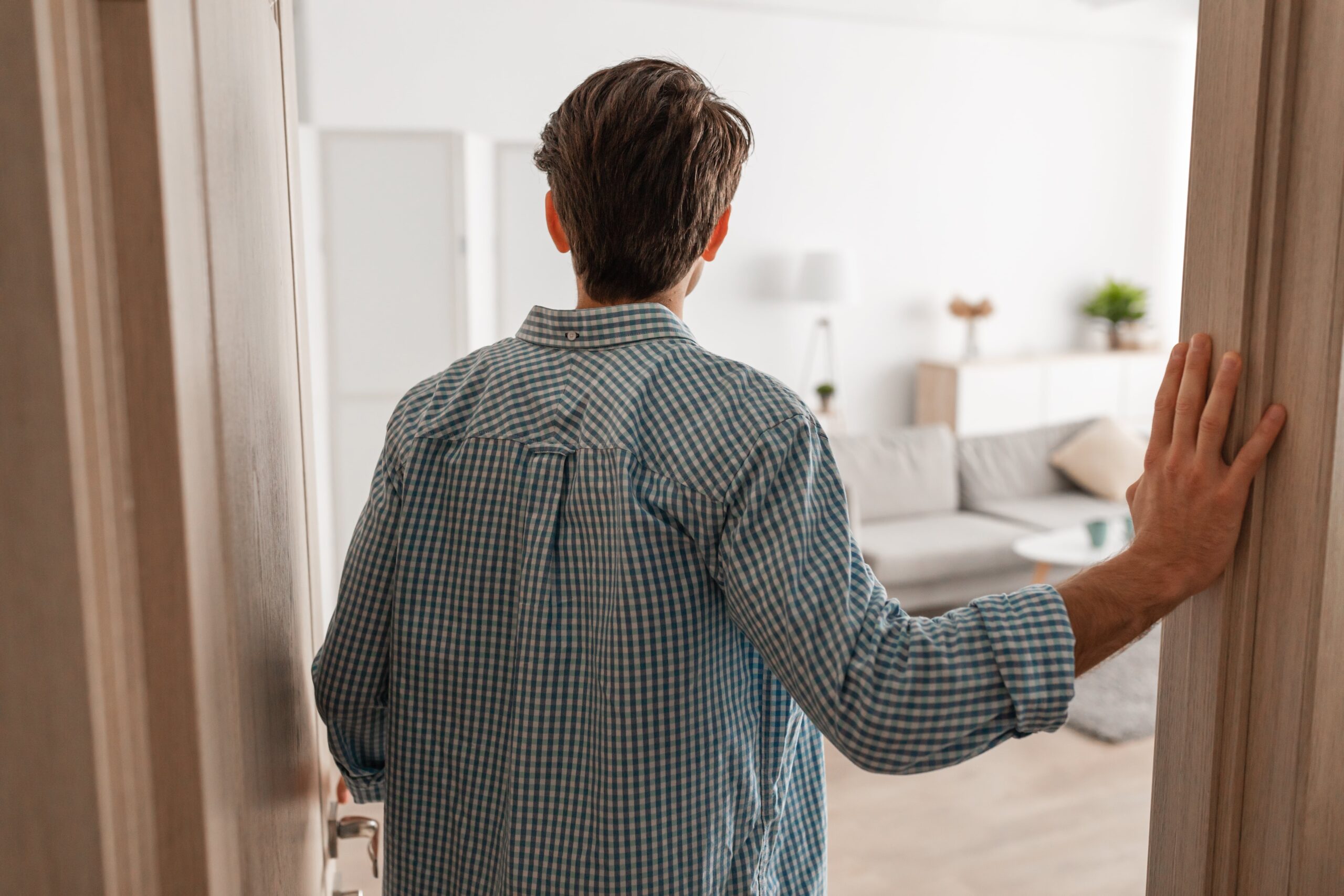 View of man walking in his apartment looking at interior design.