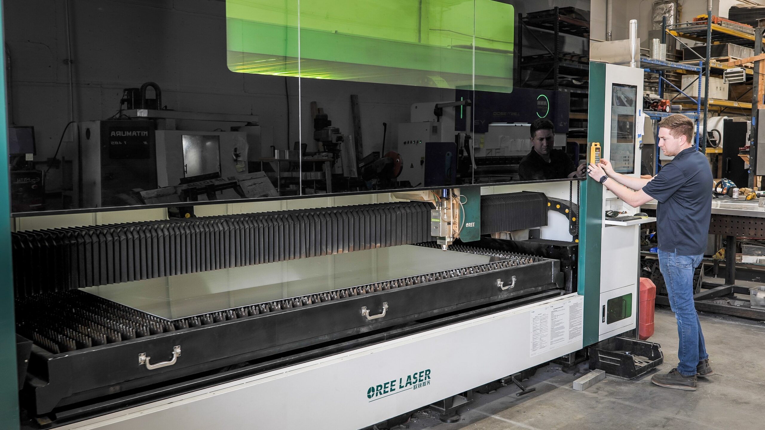 Engineer managing a CNC machine for door being design.